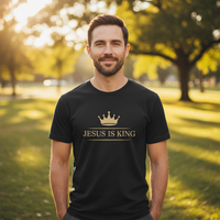 Load image into Gallery viewer, jesus-is-king-premium-heavyweight-t-shirt worn by a man in a park, celebrating his faith with a stylish crown design.